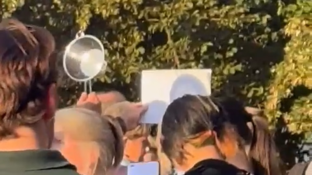Second man leverages colander at packed London park to observe the eclipse… and he's not alone