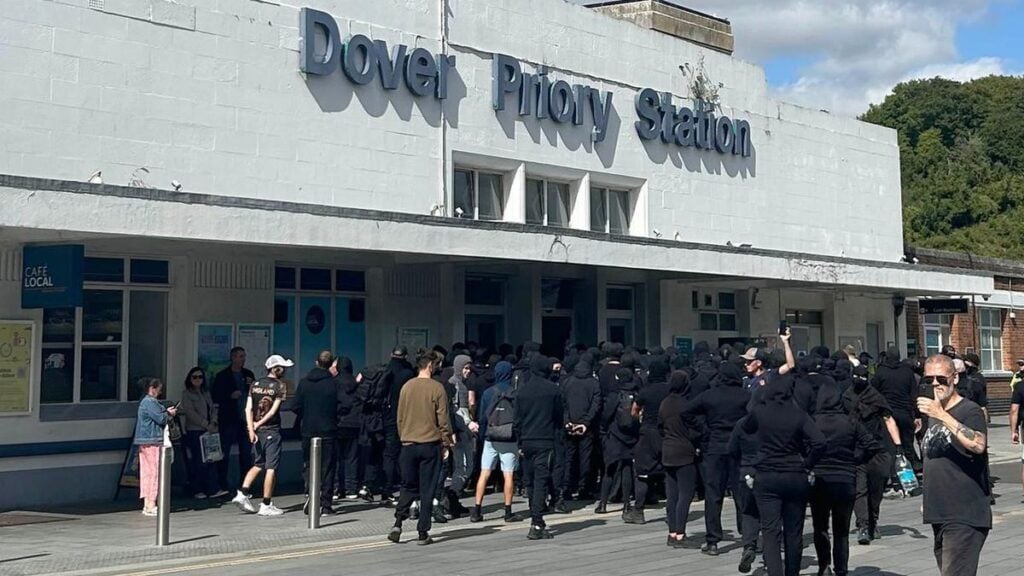 Masked men block port roads during protest over small boats