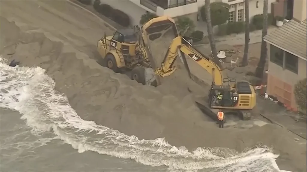 Excavators work to shield California homes from pounding surf